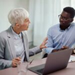 African American entrepreneur talking his business mentor on a meeting in the office.